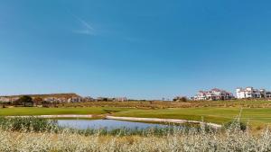 a golf course with a pond and buildings in the background at Casa Indico J-Murcia Holiday Rentals Property in Sucina