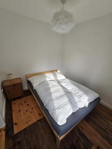 a bed in a room with a white wall at seenahes Ferienidyll in Wustrow