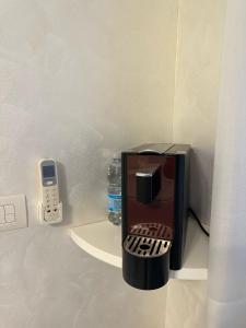 a coffee maker with a cell phone next to a bottle of water at Belvedere in Castro di Lecce