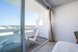 a bedroom with a table and a chair on a balcony at Formentera Especial in La Savina
