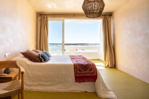 a bedroom with a bed with a large window at Formentera Especial in La Savina