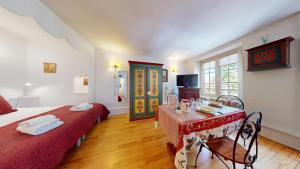a bedroom with two beds and a table with a red blanket at Le Clos bartholdi in Colmar