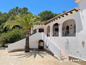a palm tree next to a building with a staircase at VH CostaBlanca - MIRASOL in Fanadix