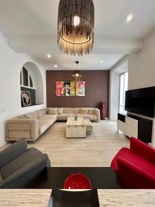a living room with a couch and a chandelier at A Casa di Lamu, eleganza in Piazza della Vittoria, 140mq in Pavia