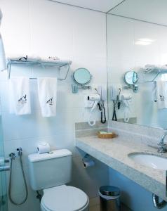 biała łazienka z toaletą i umywalką w obiekcie Pampulha Lieu Hotel w mieście Belo Horizonte