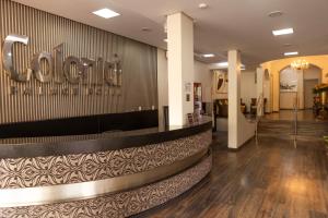 a lobby of a hotel with a sign on the wall at Colonial Palace Hotel in Pará de Minas