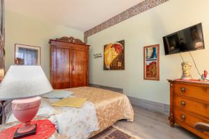 a bedroom with a bed with a lamp and a dresser at Casa Kita in Cortona