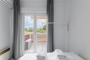 Un dormitorio con una cama y una ventana grande. en F & B Summer Collection - Sithonia - Family Maisonette, en Ormos Panagias