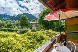 - Balcón con mesa y sombrilla en Ferienwohnung Edelweiß, en Schönau am Königssee