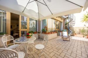 a patio with a table and chairs and an umbrella at CasAdòro in Arezzo