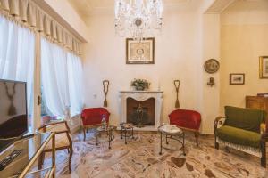 a living room with a fireplace and red chairs at CasAdòro in Arezzo