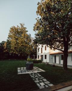 a yard with a tree and a building at Bassano Club House in Bassano del Grappa