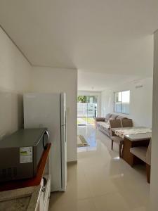 eine Küche mit einem Kühlschrank und ein Wohnzimmer in der Unterkunft Casa prox. a praia do Campeche in Florianópolis