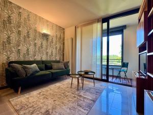a living room with a green couch and a table at La Libellula - [Parcheggio gratuito] in Alba