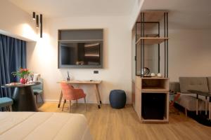 una stanza con un letto, un tavolo e una scrivania di Hotel Poseidon a Torre del Greco