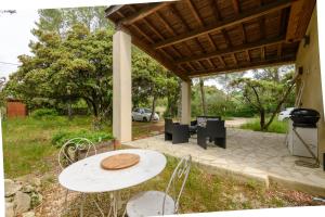 Un patio con mesa y sillas y parrilla. en Garrigue de Nîmes - Climatisé avec piscine partagée, en Nimes