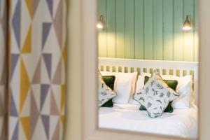 a reflection of a bed with pillows in a mirror at The Tack Room in Stowmarket