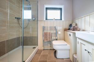 a bathroom with a shower and a toilet and a sink at The Tack Room in Stowmarket +24 photos