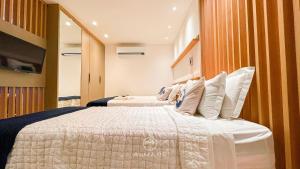 a hotel room with two beds and a television at Flat FM20 Cabo Branco Piscina Privativa - By Almare in João Pessoa