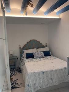 a bedroom with a bed with blue pillows on it at Casita pescadores recién reformada frente al mar in Torrenostra