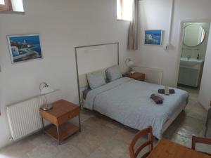 a bedroom with a bed and a table and a mirror at Skarinou Village Poolside Escape Studio with Pool facilities in Skarinou