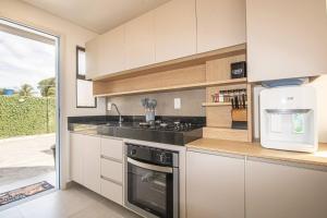 eine Küche mit Spüle und Herd oberen Backofen in der Unterkunft OKA Milagres Cond. Beira Mar para 08 Pessoas in Barra do Camaragibe