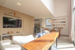 ein Wohnzimmer mit Tisch und Couch in der Unterkunft OKA Milagres Cond. Beira Mar para 08 Pessoas in Barra do Camaragibe