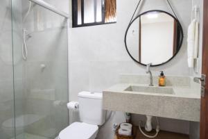 ein Badezimmer mit Toilette, Waschbecken und Spiegel in der Unterkunft Casa Milagres 03 suítes - a 300m da Praia in Tatuamunha + 17 Fotos