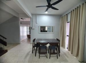 a dining room with a table and chairs and a ceiling fan at Nuri Homestay Rusila 2 in Kuala Terengganu +11 photos