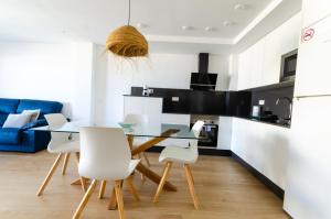 a kitchen and dining room with a glass table and white chairs at Garrucha Blue Horizon in Garrucha