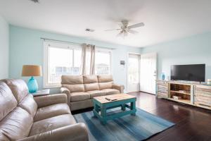 a living room with a couch and a table at Near Beach Dining & Shops Private Hot Tub in Kill Devil Hills