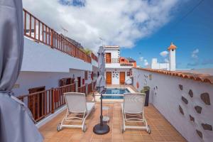 a balcony with chairs and a swimming pool on a house at Casa Justina in Garachico