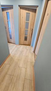 une chambre vide avec deux portes et du parquet dans l'établissement Noclegi w Łodzi, Komfortowe Pokoje, Wielkopolska 39, à Łódź