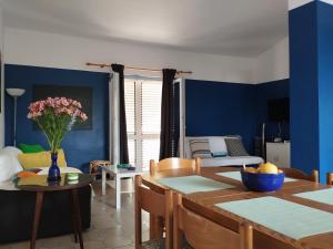 a living room with blue walls and a table and chairs at Ervin cosy two bedroom apartment center in Novalja
