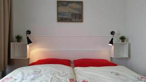 a bedroom with a bed with two red pillows at DUINZICHT 6 Bed by the Sea in Westkapelle