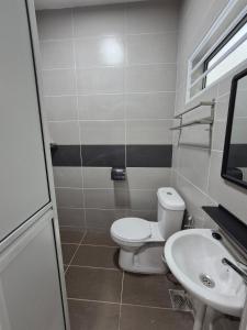 a bathroom with a toilet and a sink at Villa Kluang 峦山居 in Kluang