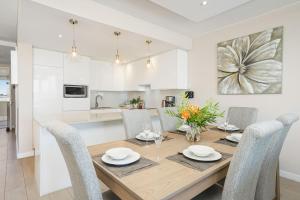 a kitchen and dining room with a wooden table and chairs at Dolphin Beach H106 by Host Agents in Bloubergstrand