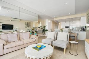 a living room with a couch and a table at Dolphin Beach H106 by Host Agents in Bloubergstrand