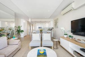 a living room with a couch and a table at Dolphin Beach H106 by Host Agents in Bloubergstrand