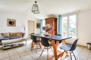 a living room with a table and chairs at Maison pour 6 à Noirmoutier - jardin - terrasse in Noirmoutier-en-l'lle