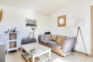 a living room with a couch and a table at Maison pour 6 à Noirmoutier - jardin - terrasse in Noirmoutier-en-l'lle