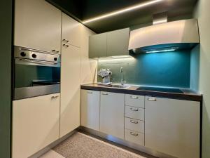a kitchen with white cabinets and a sink at La Libellula - [Parcheggio gratuito] in Alba