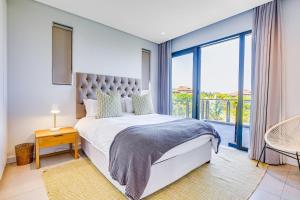a bedroom with a bed and a large window at Oceans Edge 3, Zimbali Estate by Euphoric Leisure in Ballito