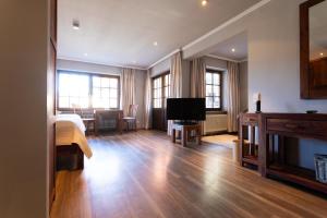 a living room with a television and a living room with a table at Appartements by Romantik Hotel zur Sonne in Badenweiler