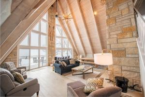 - un salon mansardé avec un mur en pierre dans l'établissement Lakefront 3BDR Luxury Home at High Bluffs Lodge 4171, à Suttons Bay