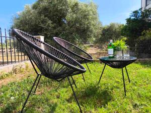 a pair of chairs and a table with a bottle of wine at Coralia's House in Nea Moudania