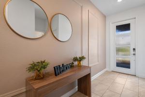 a hallway with two mirrors and a wooden table at Gorgeous 6-bedroom house with private pool in Kissimmee