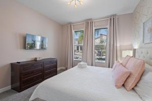 a bedroom with a bed with a dresser and a window at Gorgeous 6-bedroom house with private pool in Kissimmee