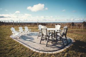 een groep witte stoelen en een tafel in een veld bij Ann Riley Farmhouse 6BDR on Yuba Vineyards - 8062 in Rapid City