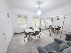 a living room with a table and chairs and a couch at Teglas Apartment in Mediaş